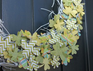 close up of grapevine wreath that has been painted white and has shamrocks cut from different green patterned papers attached to it